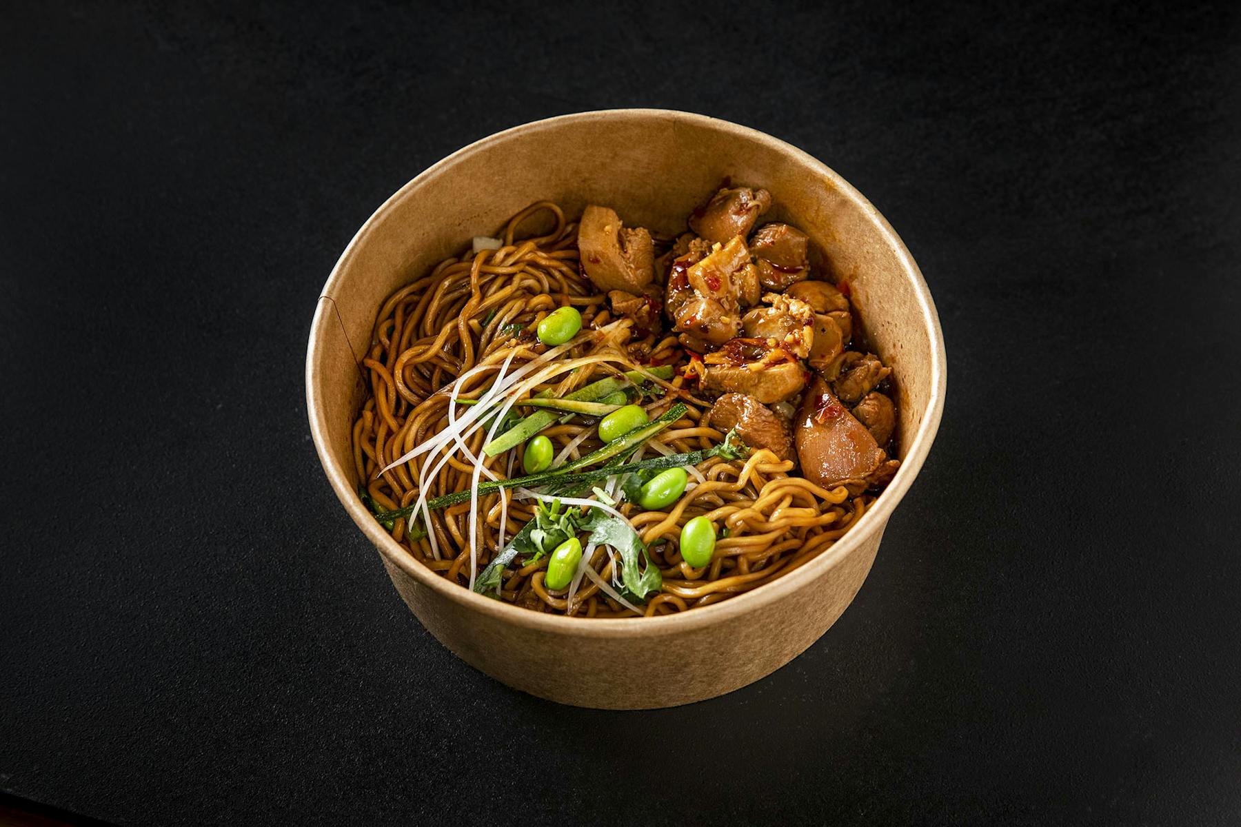 a bowl of noodles topped with veggies