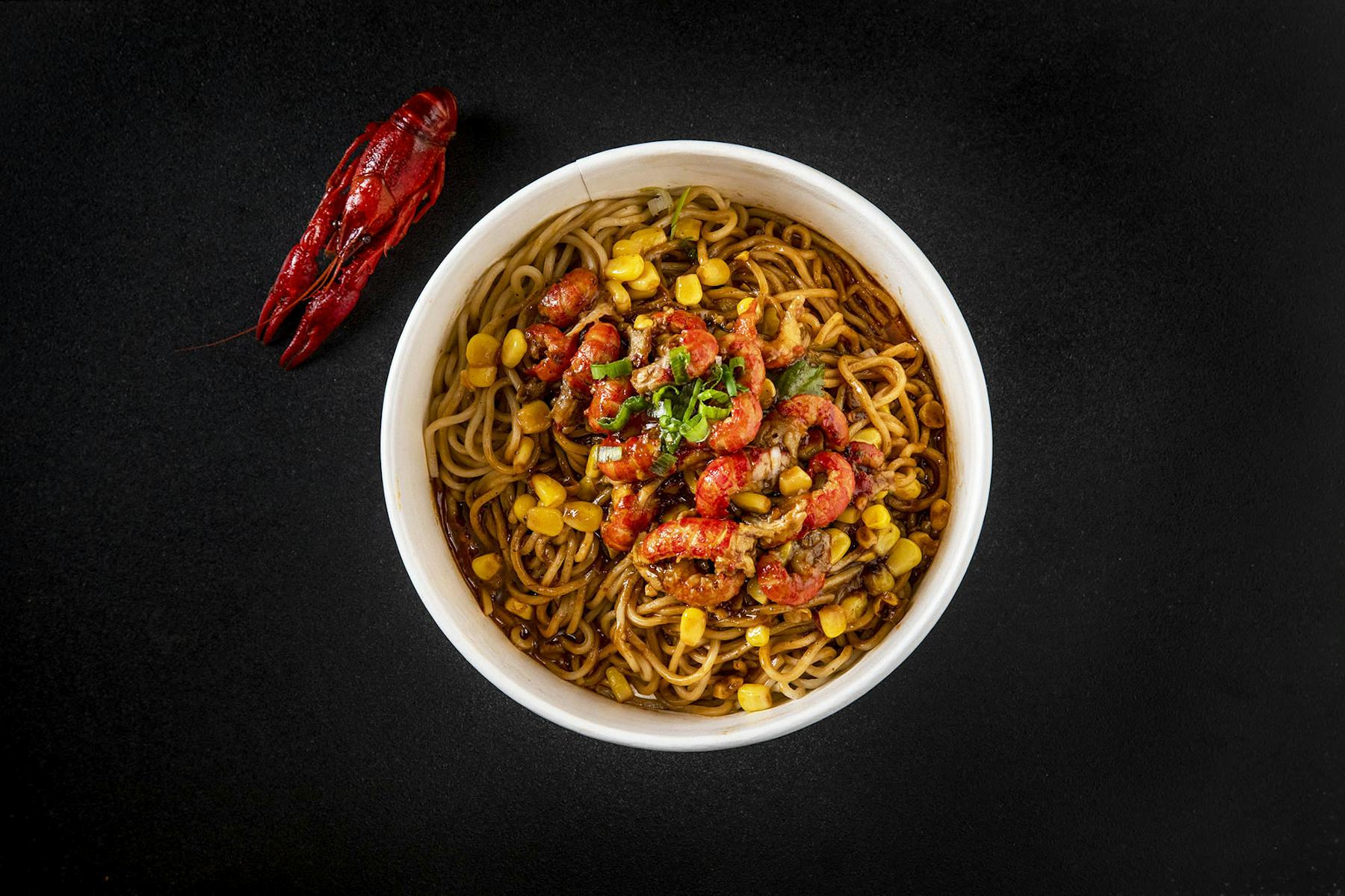 a bowl of noodles topped with shrimps