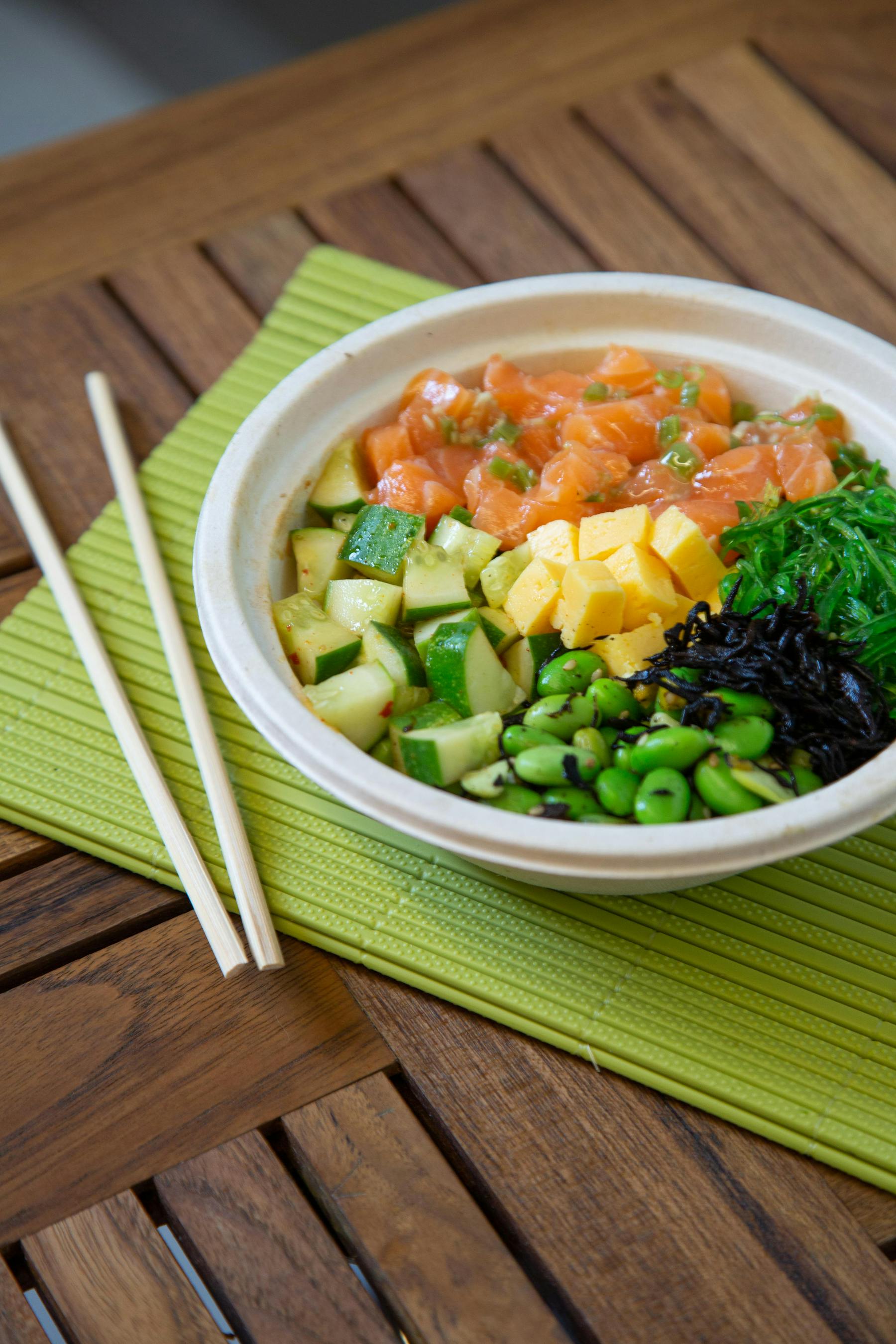 a bowl of noodles with veggies, corn, and meat