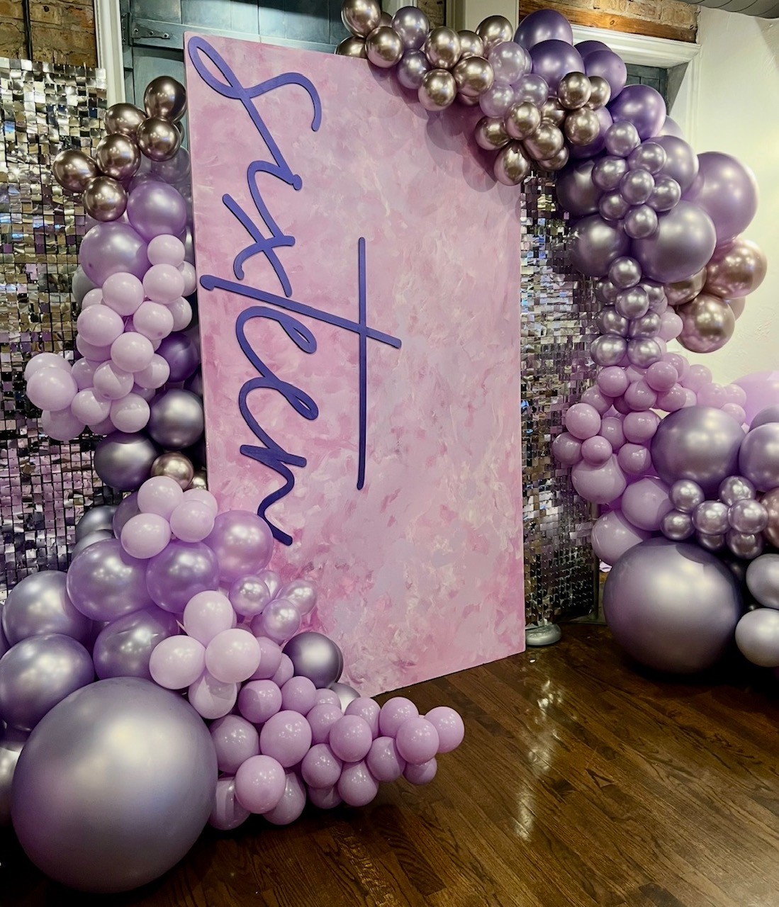 a pink and purple balloon arch