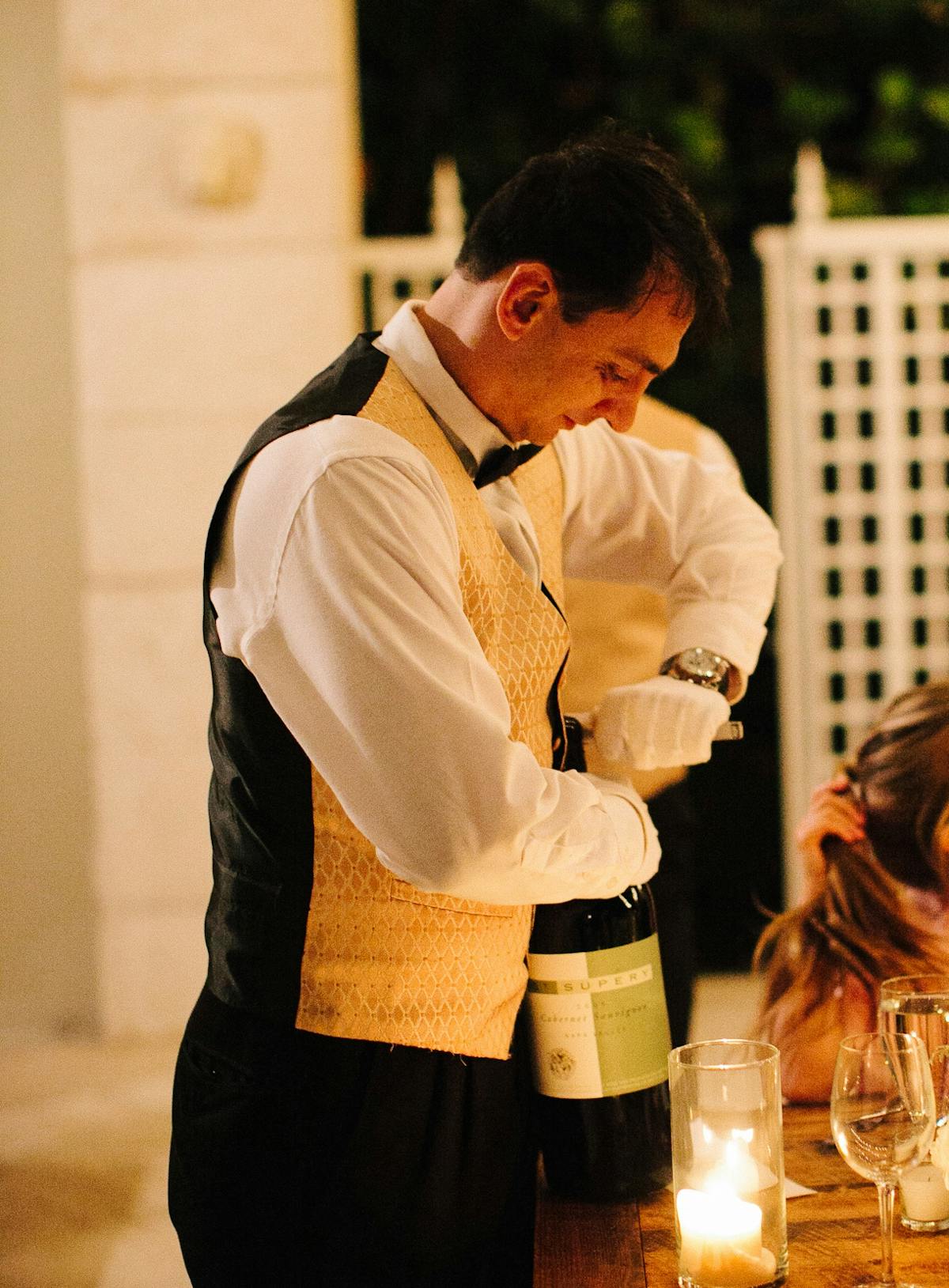 a person opening a bottle of wine