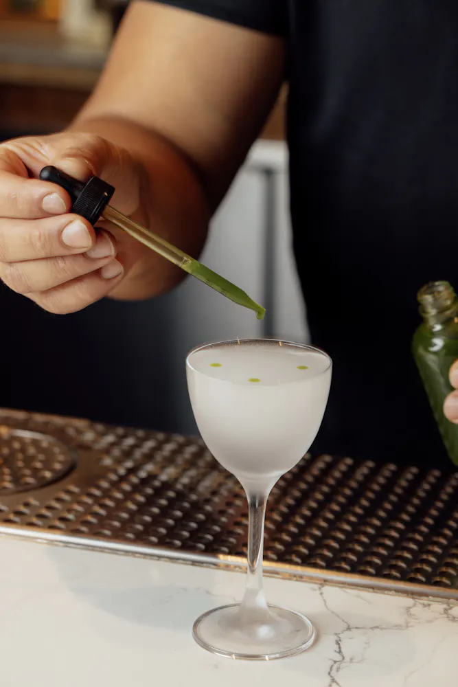 a person pouring liquid into a glass