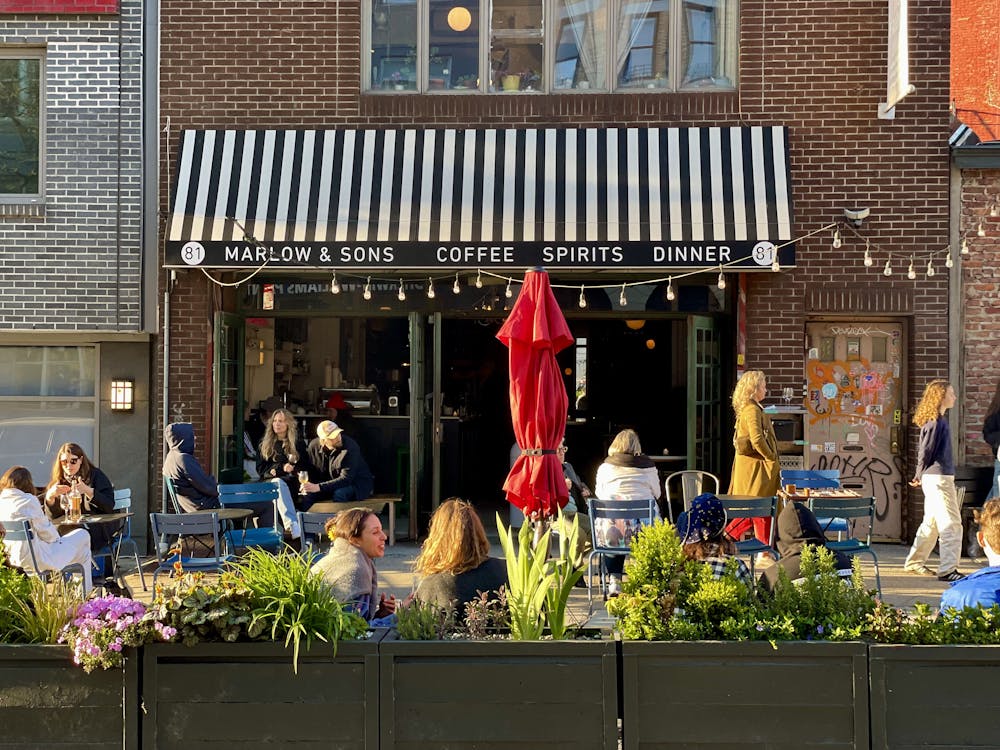 a group of people walking in front of a restaurant