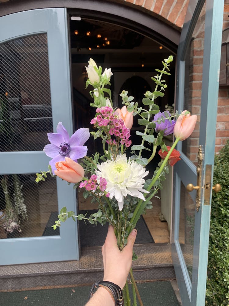 a vase of flowers sits in front of a building