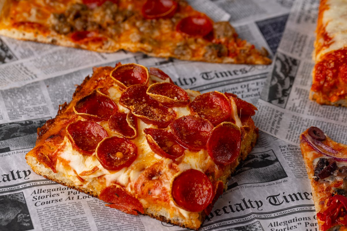 a slice of pizza sitting on top of a piece of paper