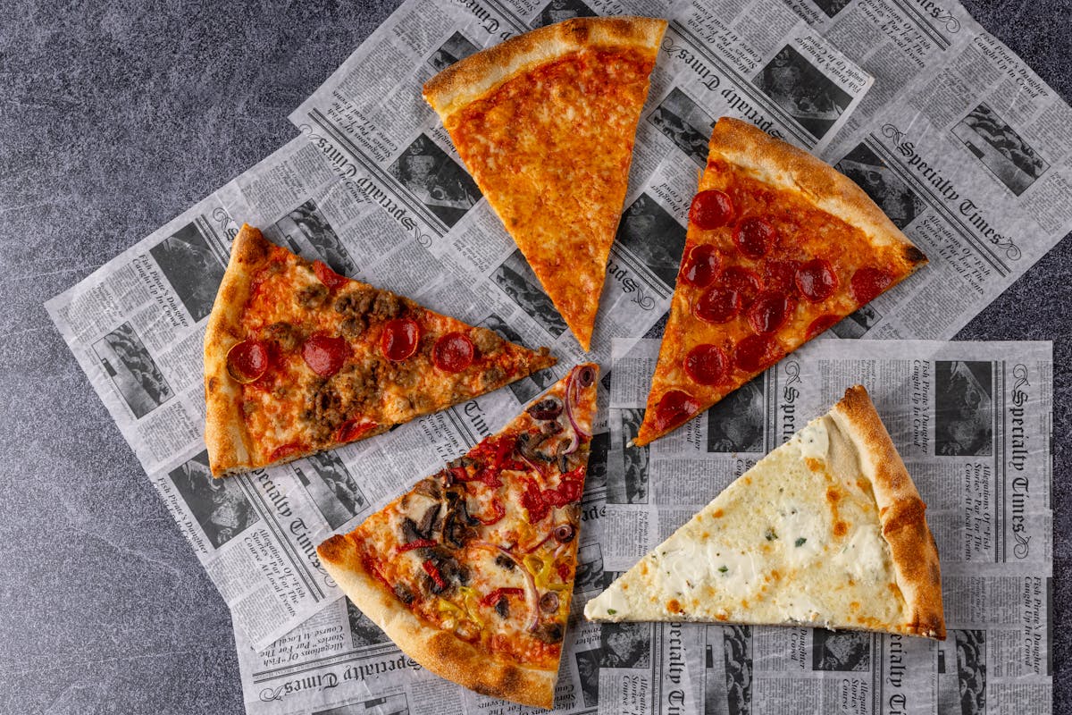 a slice of pizza sitting on top of a piece of paper