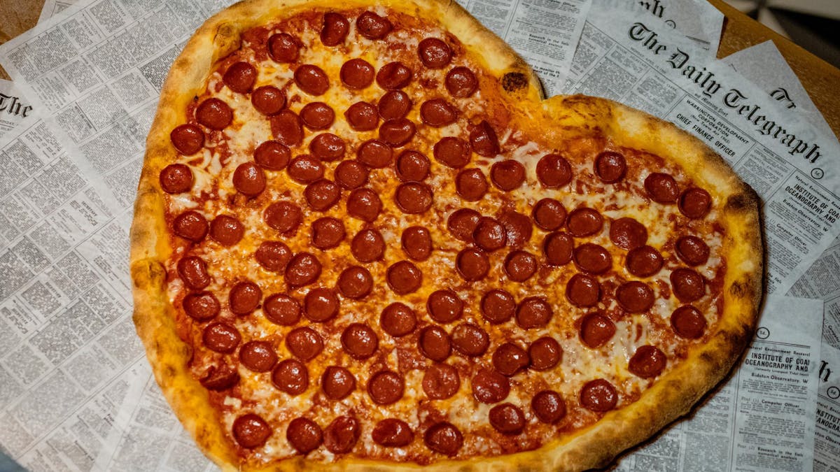 a slice of pepperoni pizza sitting on top of a table