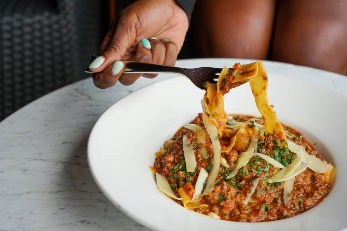 a person sitting at a table with a plate of food