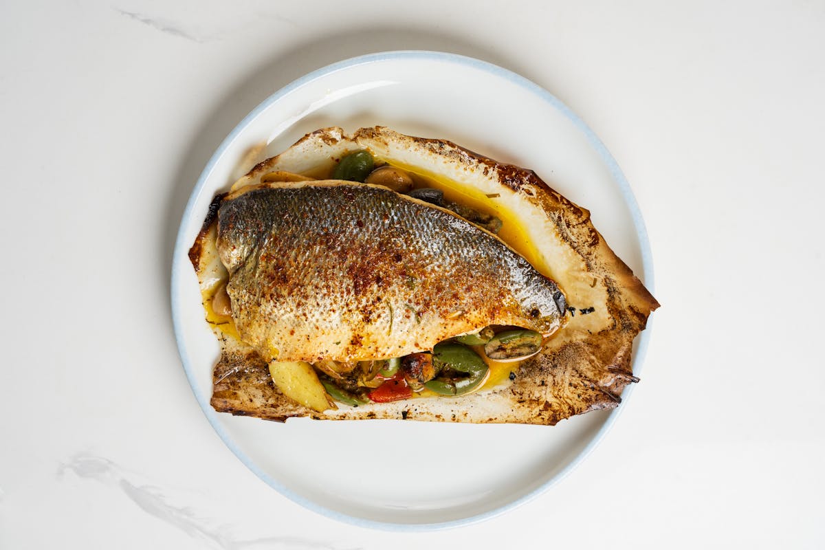 a plate of fish with vegetables