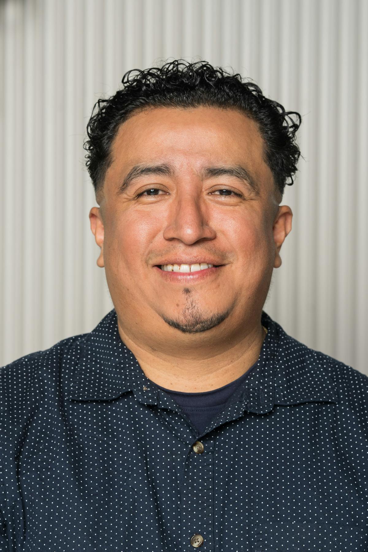 a man smiling with a dark shirt