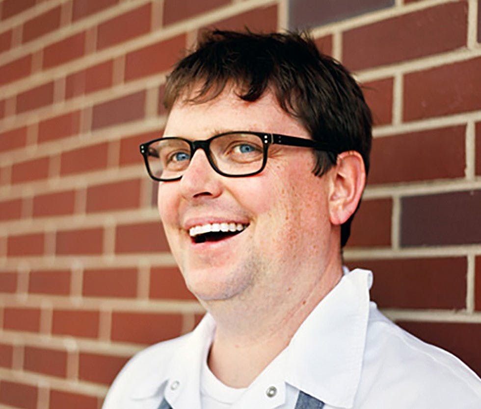 a man wearing glasses and looking at the camera
