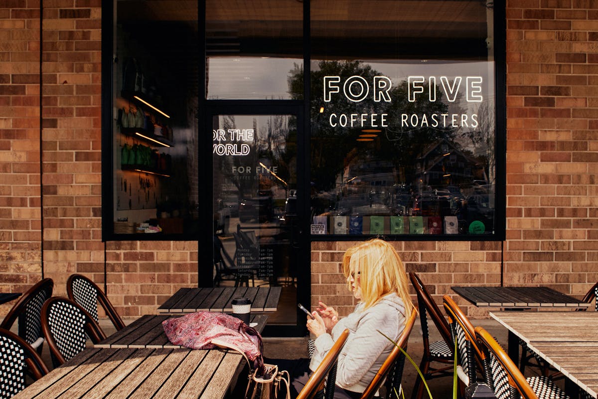 a person sitting on a bench in front of a store