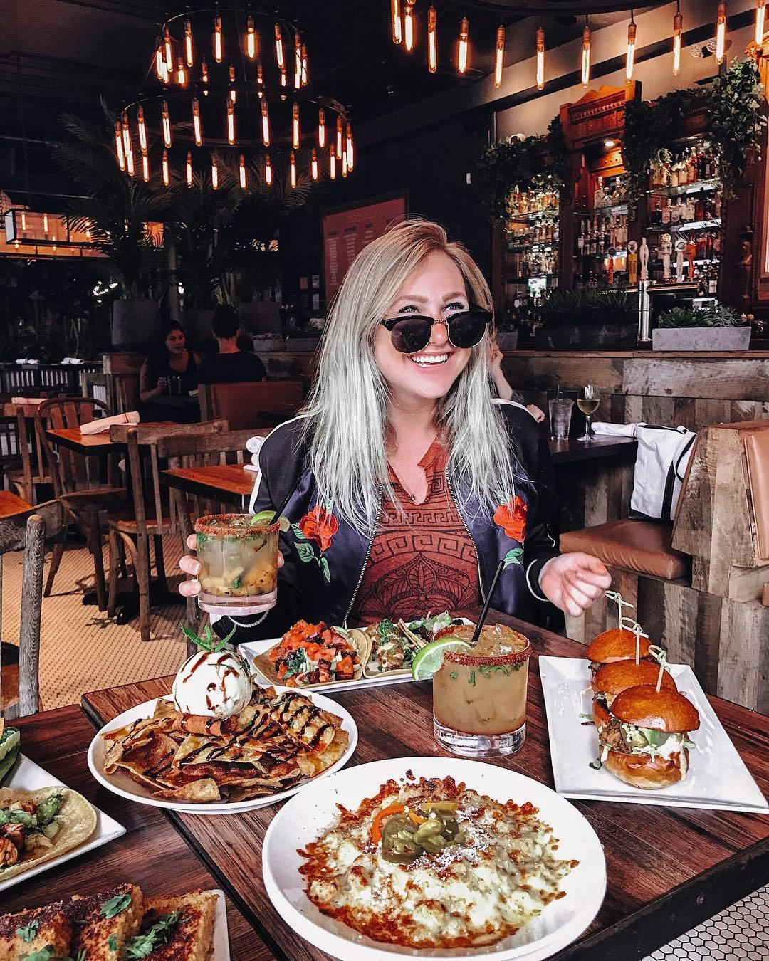 a woman sitting at a table with a plate of food