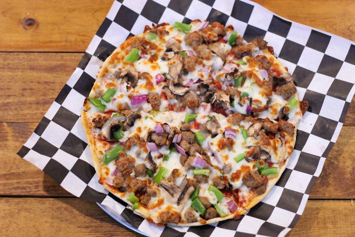 a pizza sitting on top of a wooden table
