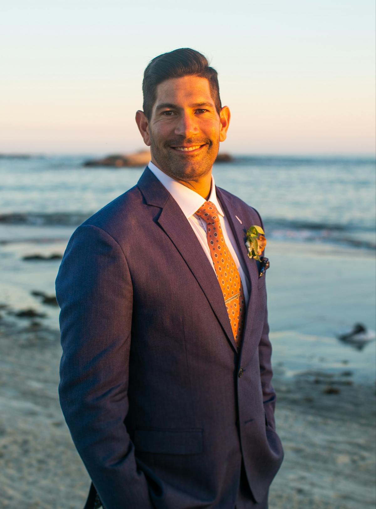 a man wearing a wet suit standing on a beach