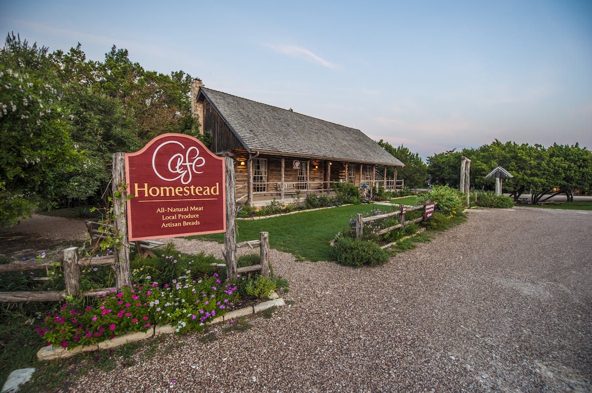 a house that has a sign on the side of a road