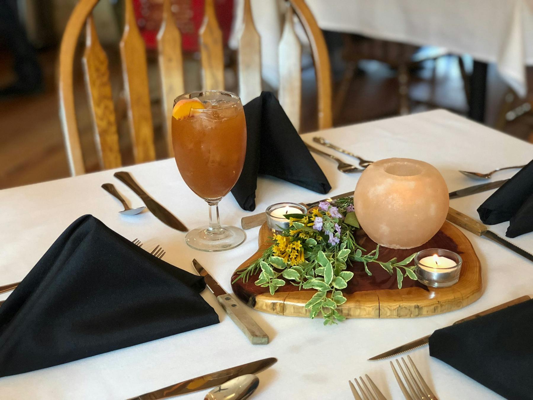 a table topped with silverware utensils and a cup of iced tea