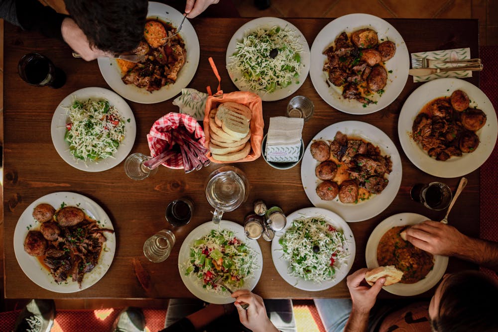 a group of people sitting at a table with a plate of food