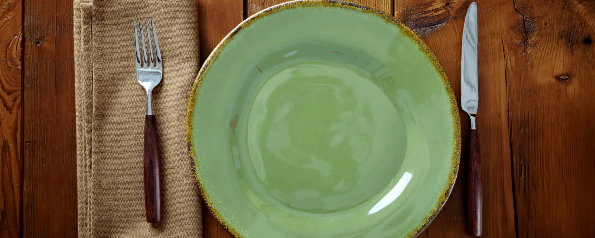 a plate with a fork on a wooden table