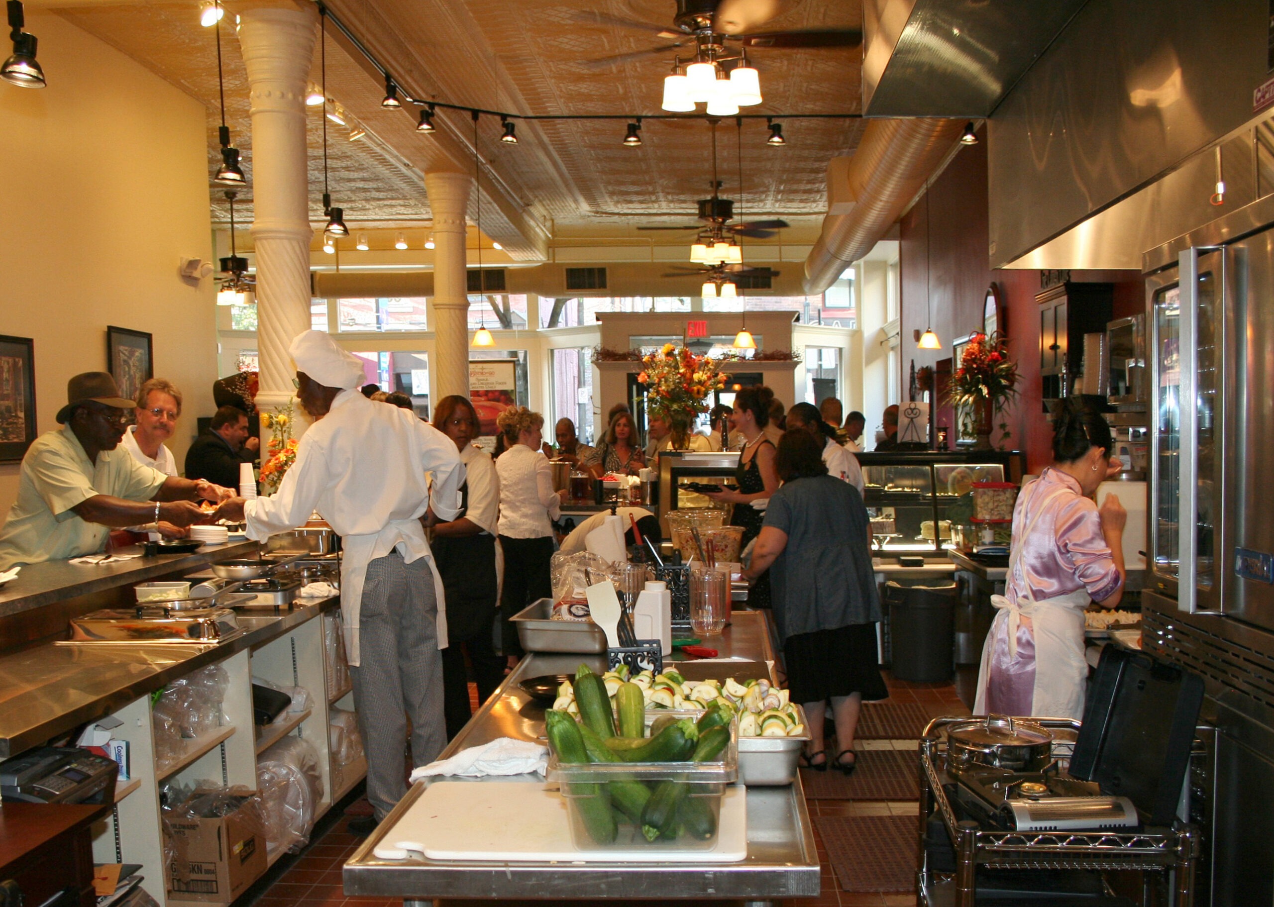 a group of people standing in a kitchen preparing food