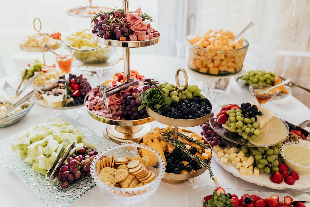 Catered food from Bistro To Go displayed at food stations with plated dishes arranged around them