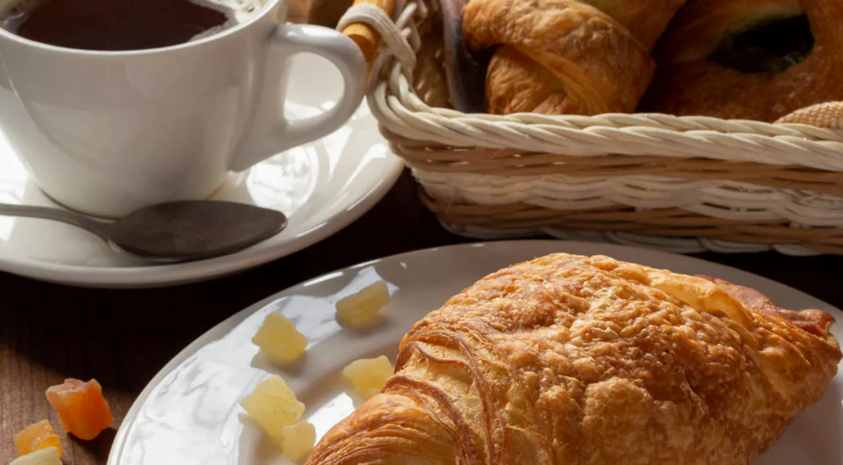 a close up of a plate of food and a cup of coffee