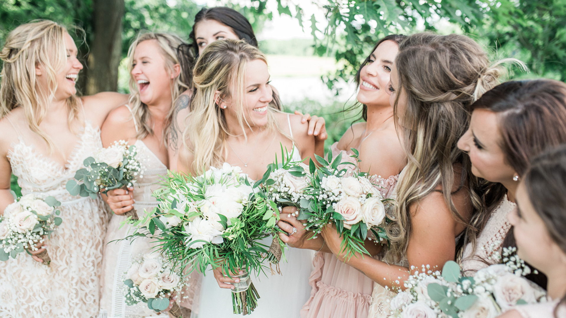 Women in wedding attire celebrating with flower bouquets