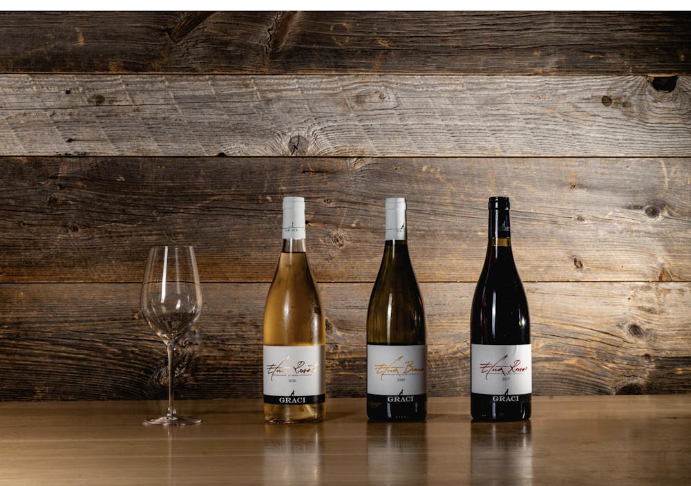 threes bottle sof wine and  an empty glass wooden table
