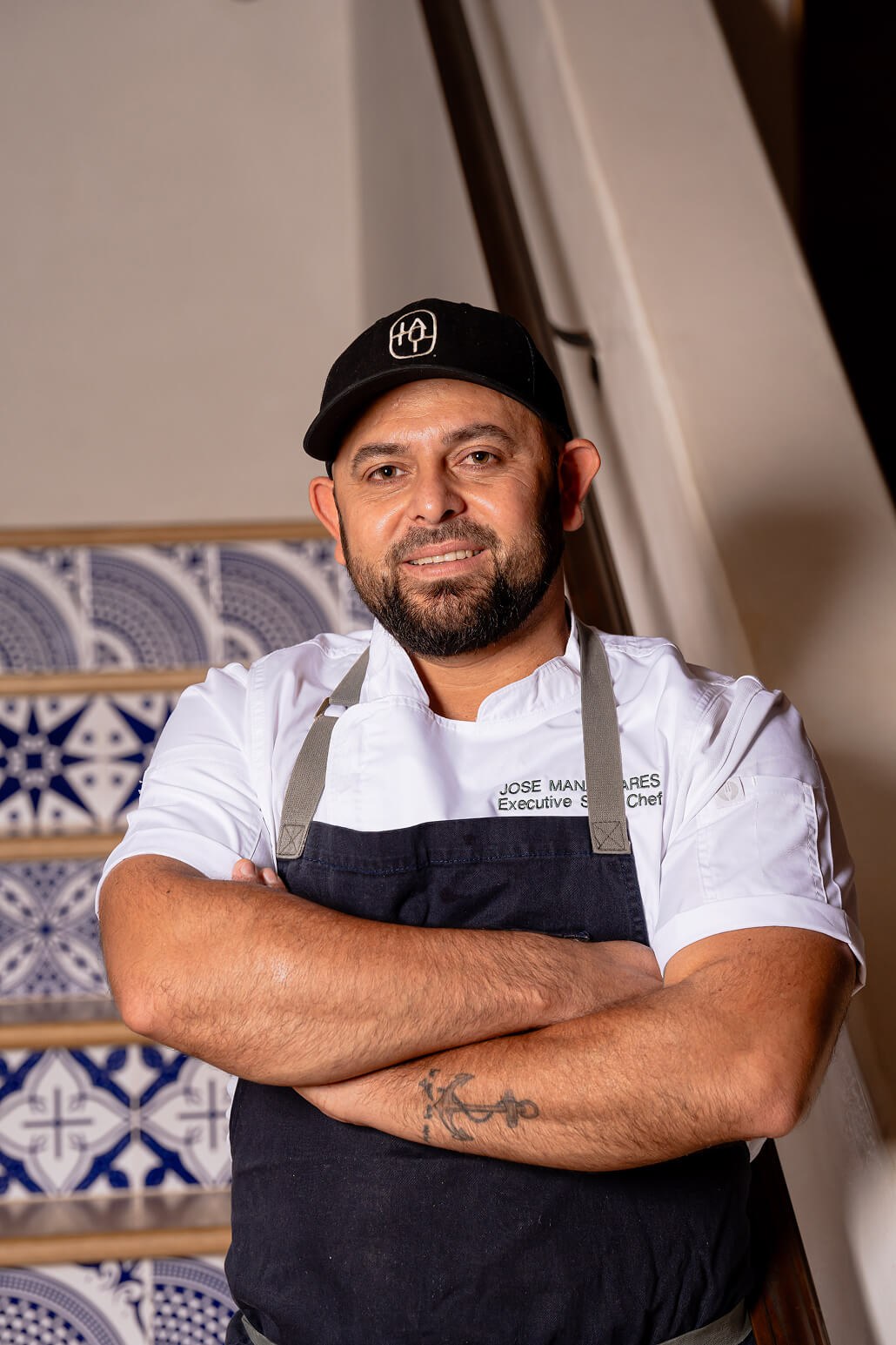 Chef Jose standing in a Latuli chef coat and cap.