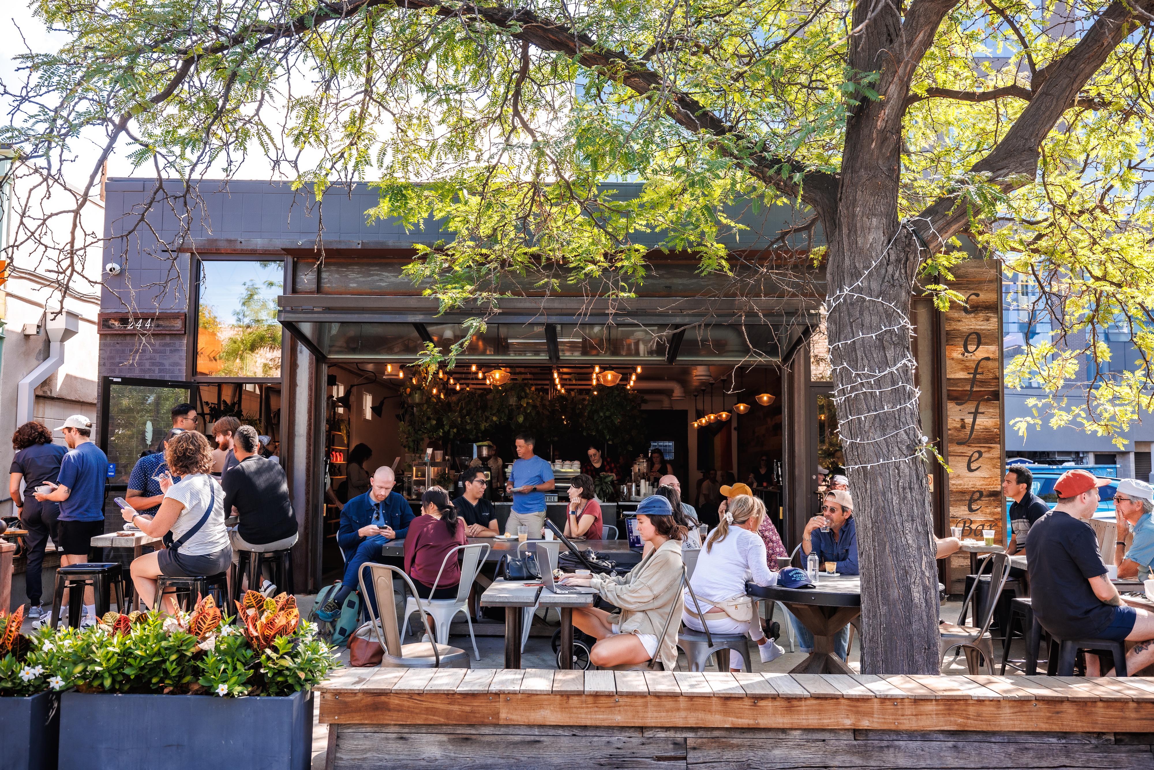 a group of people sitting at tables outside a restaurant