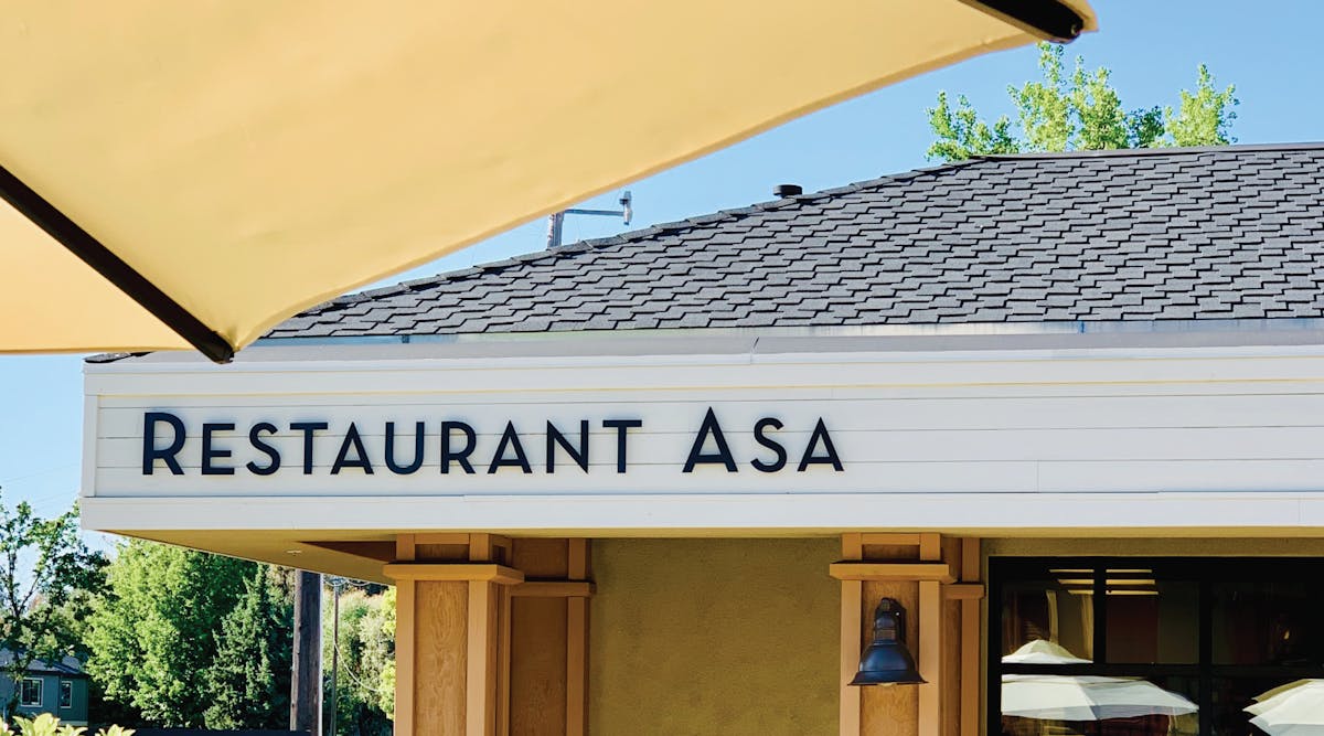 a yellow sign hanging off the side of a building