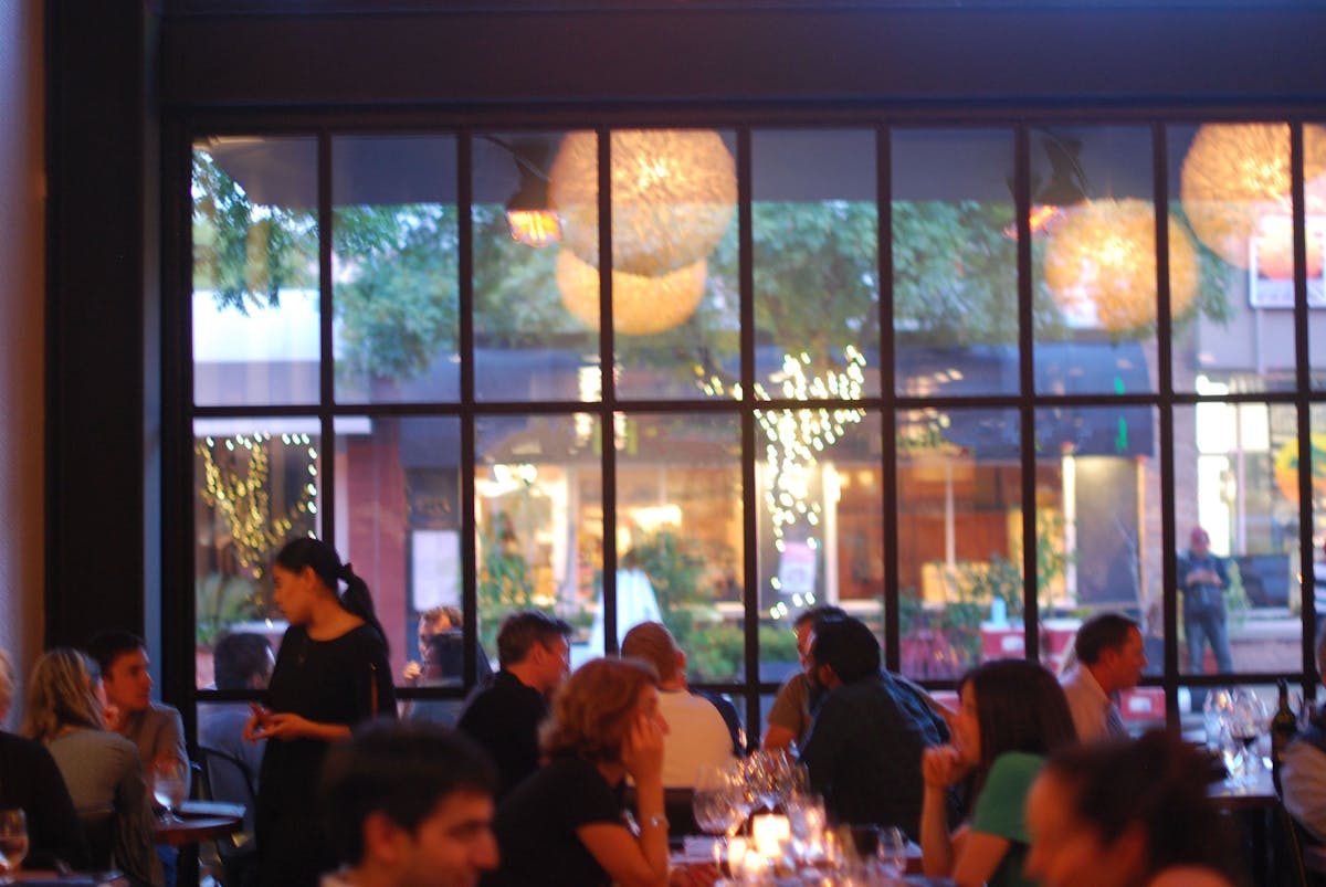 a group of people sitting at a table in front of a window