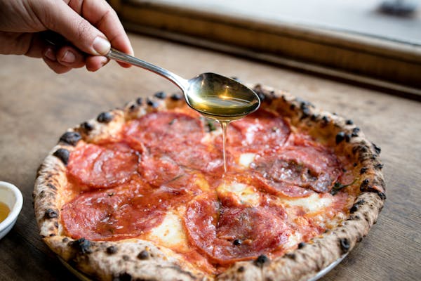 a close up of a person cutting a piece of pizza