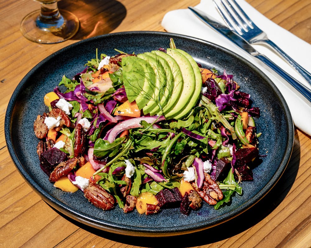 a plate full of food sitting on top of a wooden table