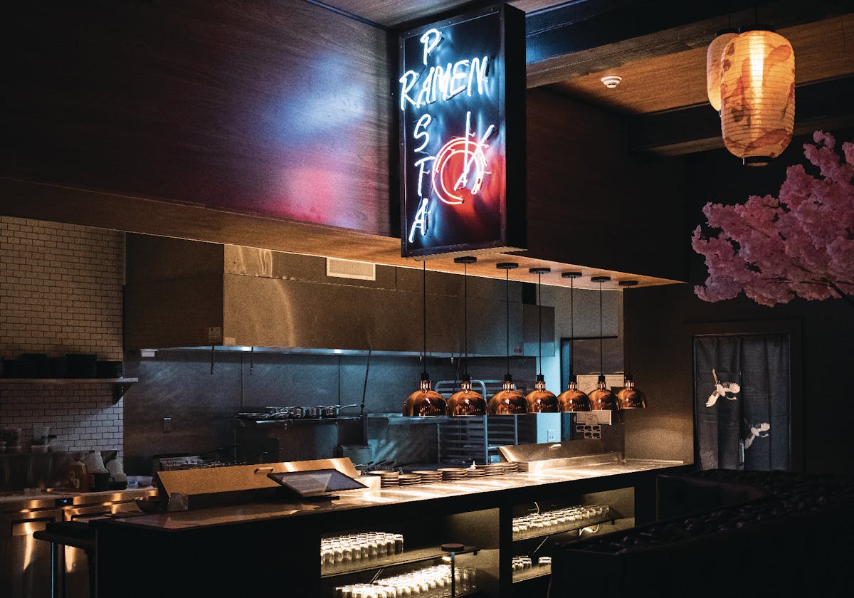 Open kitchen at pastaRAMEN Montclair with neon Wafu Italian ramen sign