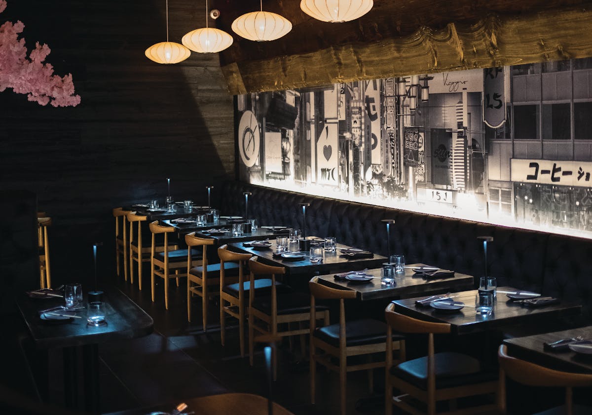 Speakeasy-style ramen restaurant interior with communal tables at pastaRAMEN