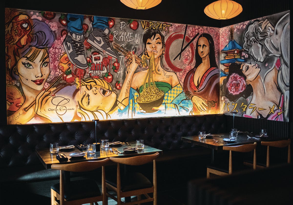 Colorful mural and booth seating inside pastaRAMEN's speakeasy-style dining room