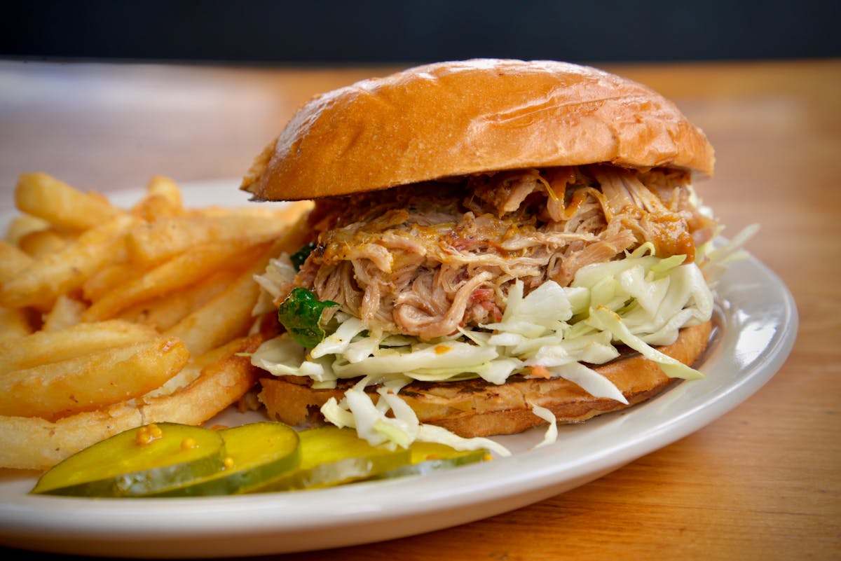 a close up of a sandwich and fries on a plate