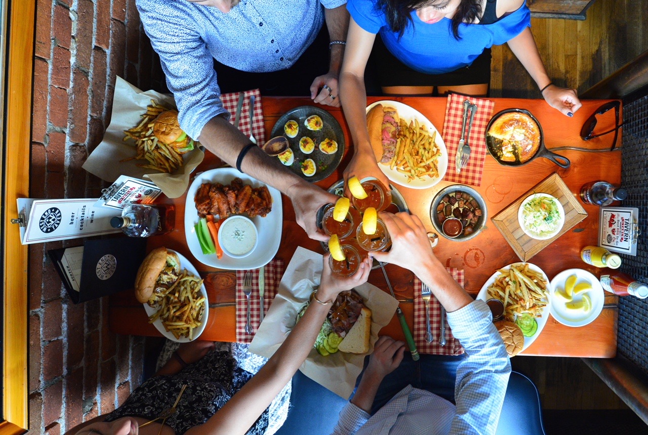 a woman holding a bunch of food on a table