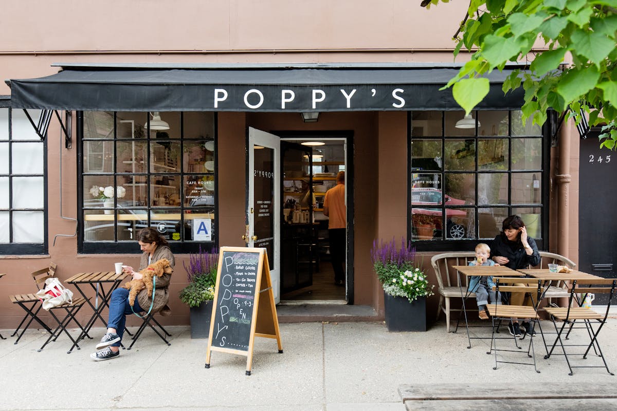 a group of people sitting on a bench in front of a building