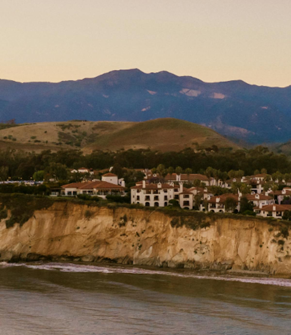 a large body of water with a mountain in the background