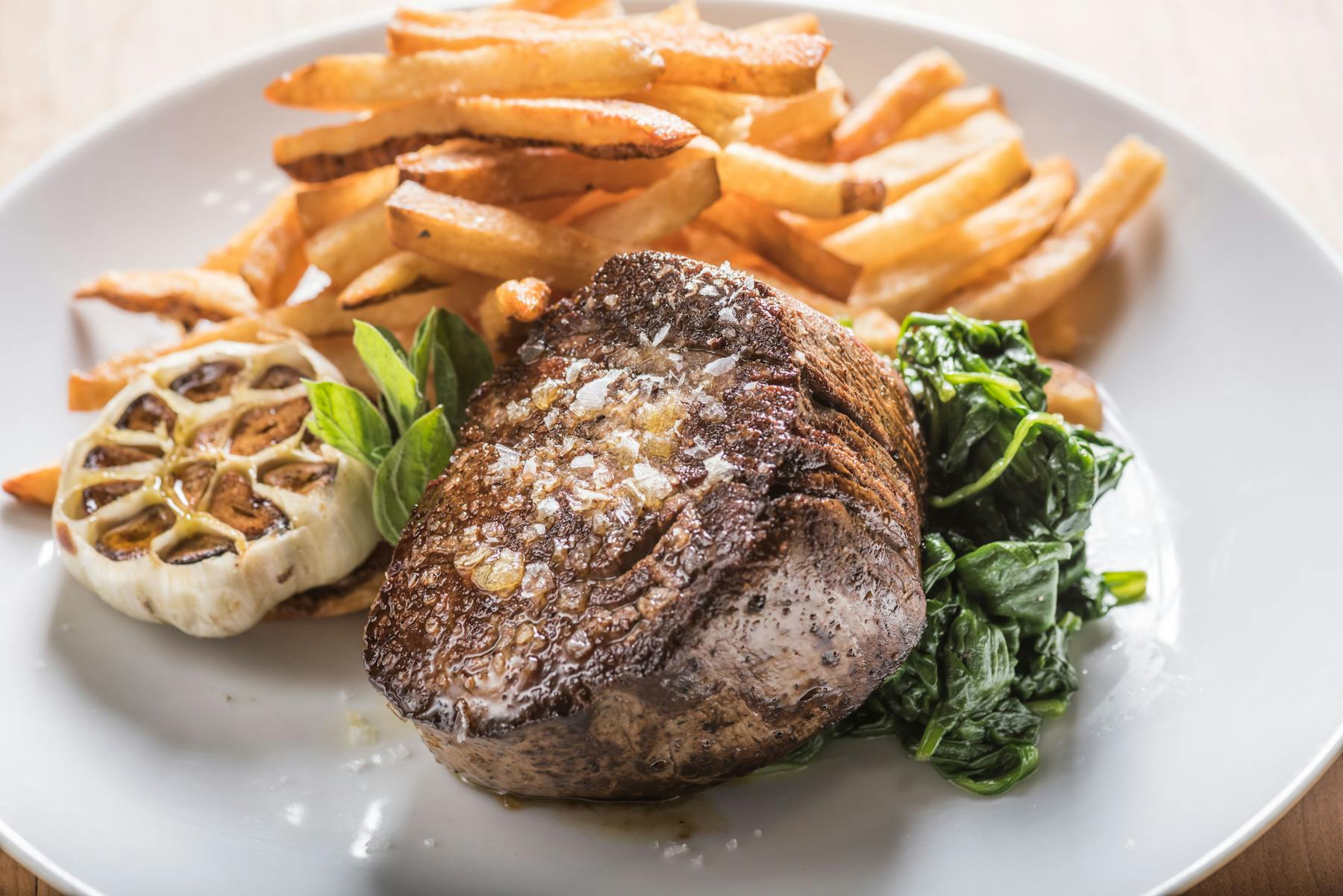 a meat plate with fries and roasted garlic