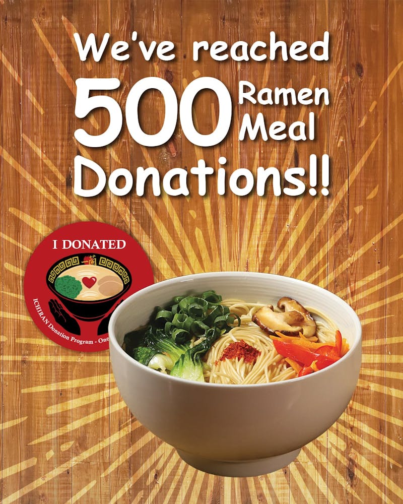 Large text on top reads "We've reached 500 ramen meal donations!!" Underneath the text is a bowl of ramen in front of a sunburst. A round sticker with an illustration of two hands embracing a bowl of ramen with a heart in the middle underneath the words "I Donated" is positioned behind the bowl.