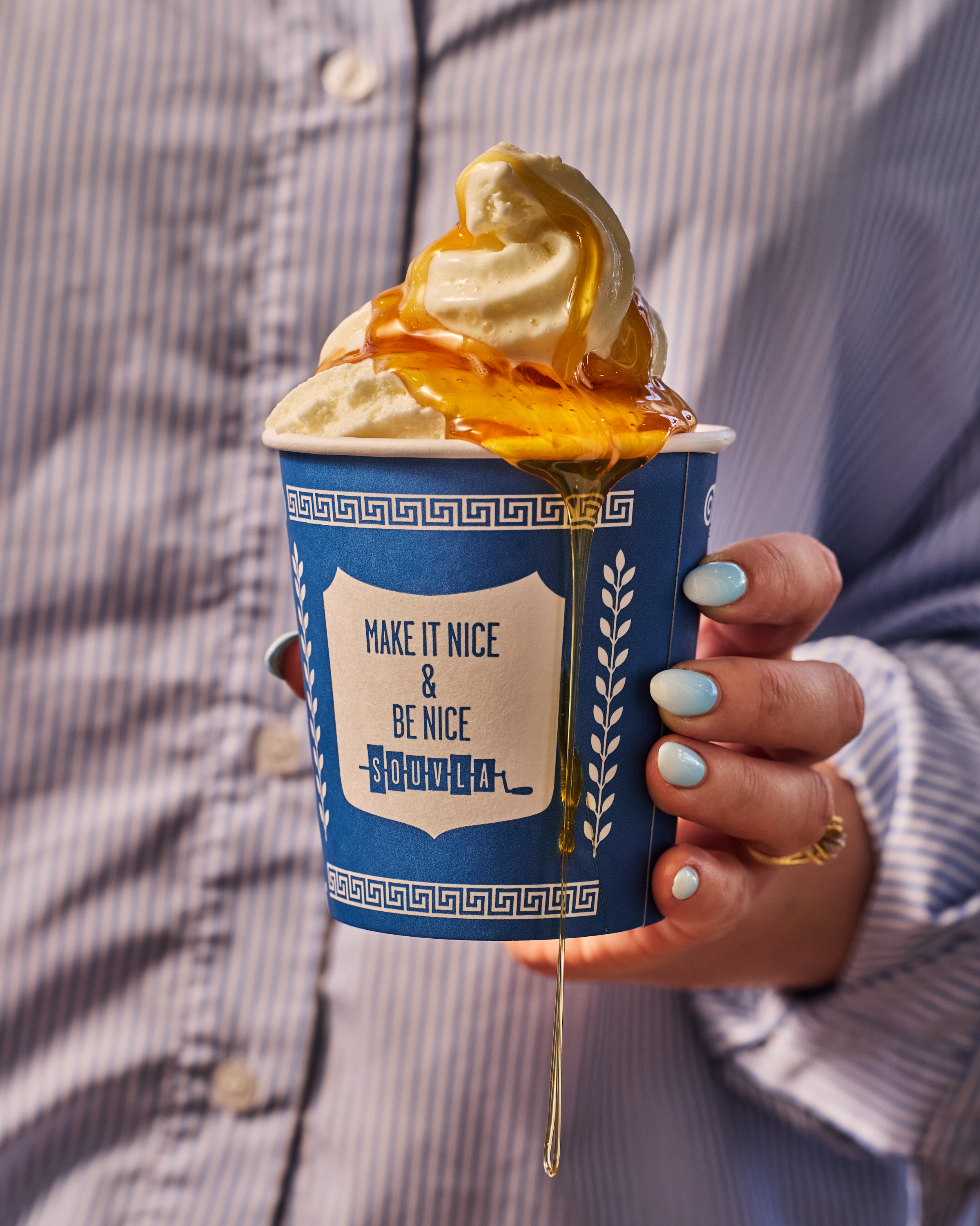 a hand holding a cup of ice cream