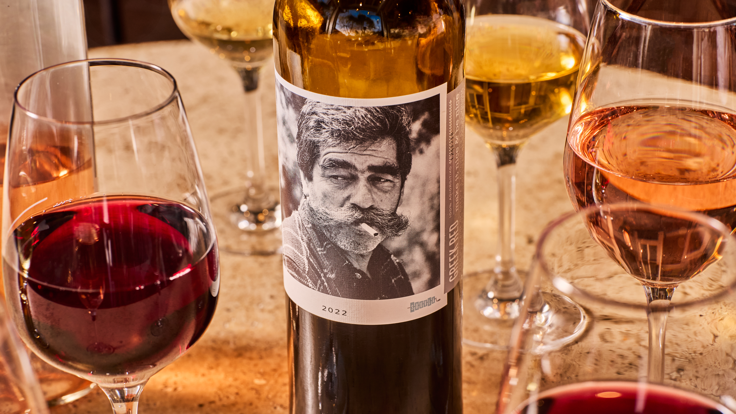 a bottle of wine next to glasses of wine