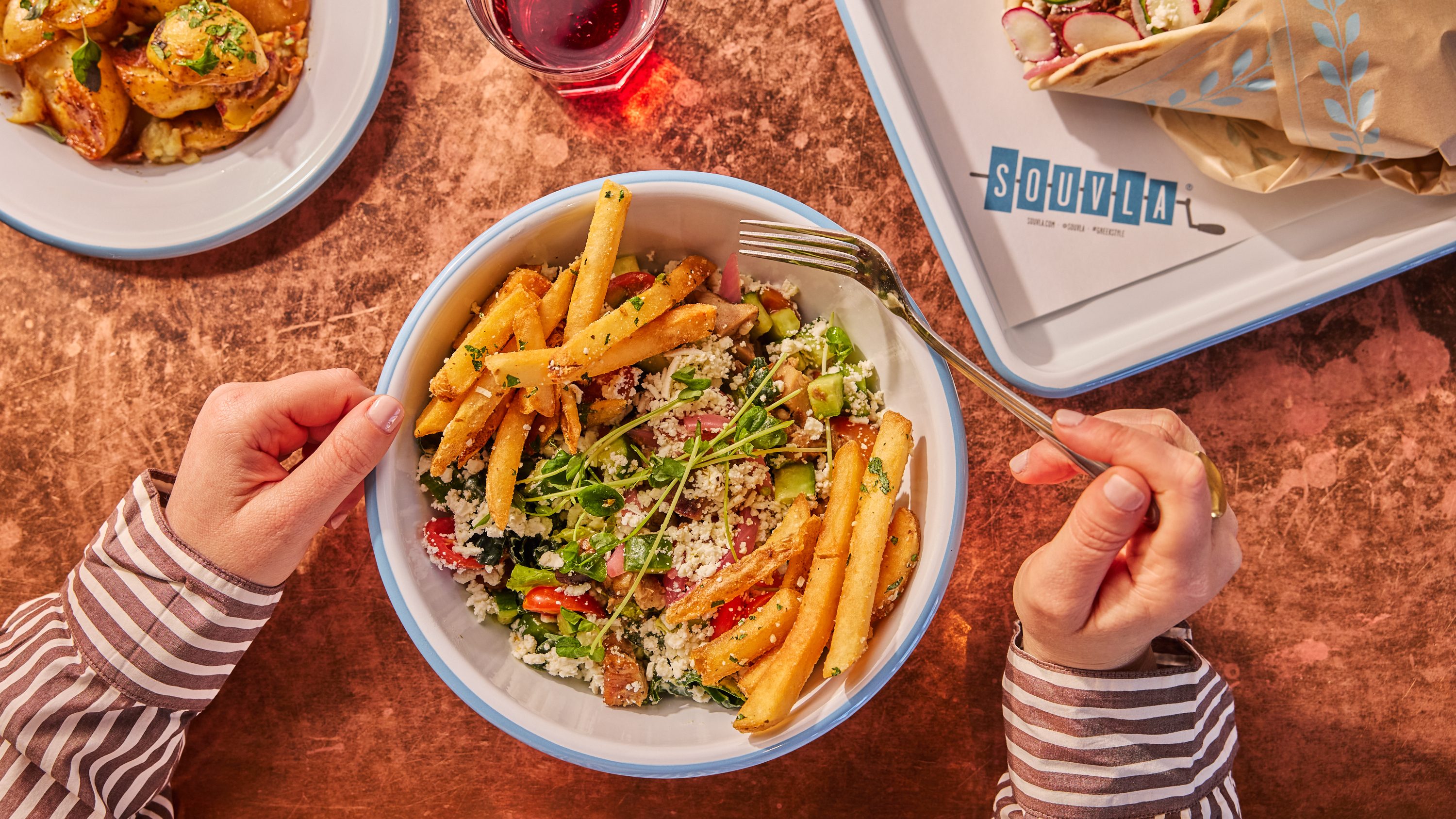 a person holding a fork in a bowl of food