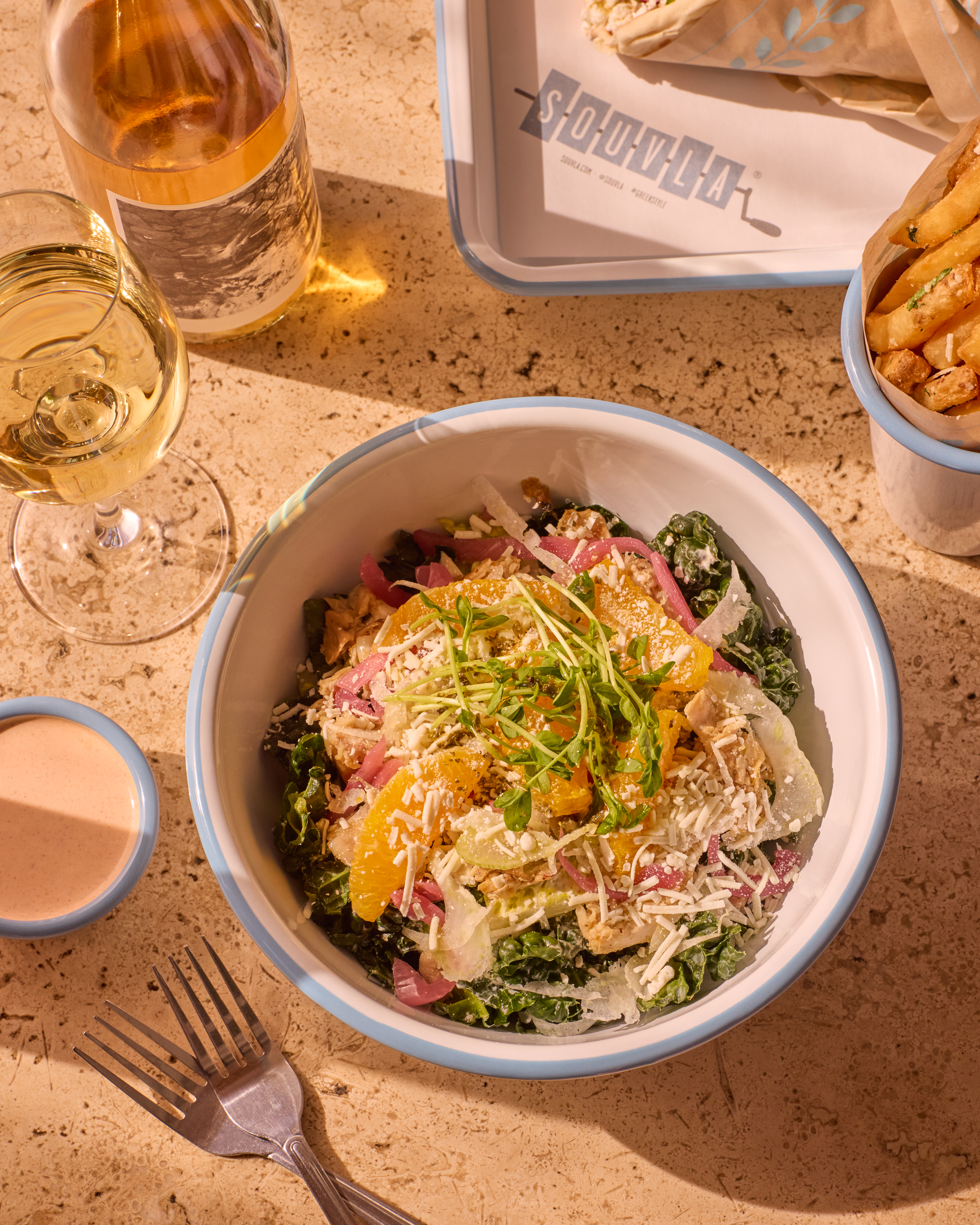 a bowl of salad and french fries