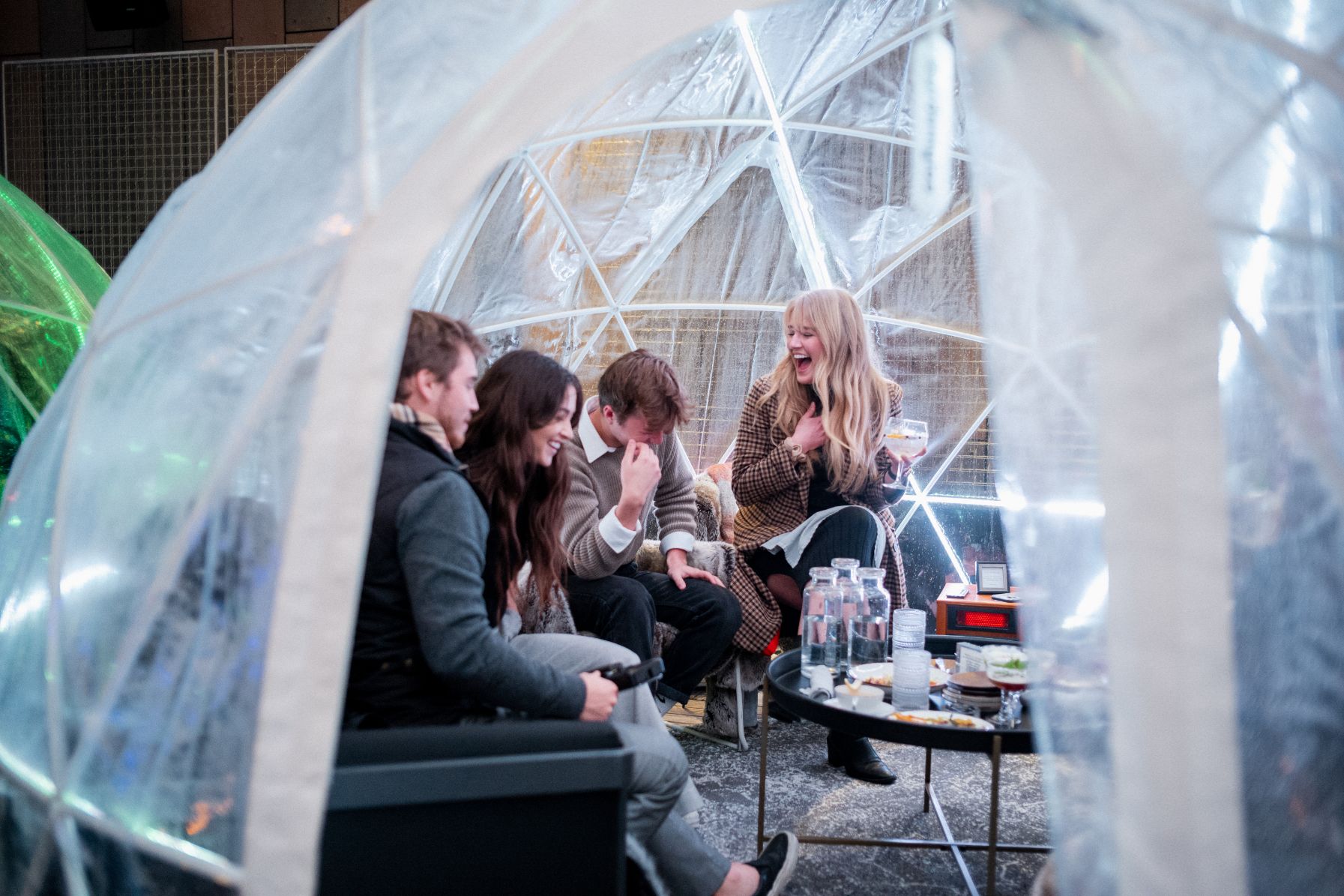 a group of people sitting in a round table in a clear dome