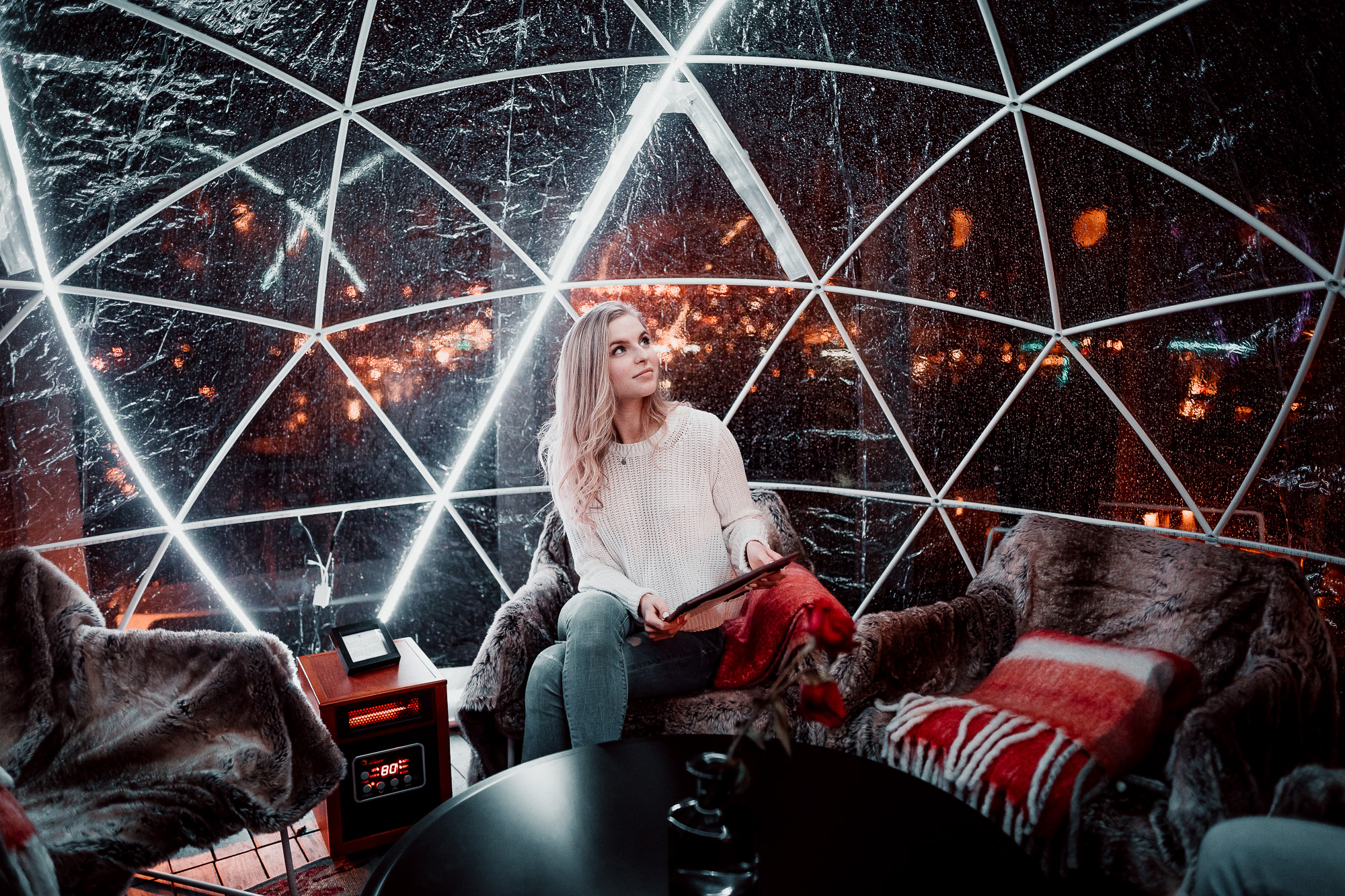 a woman sitting in a chair in front of a glass dome