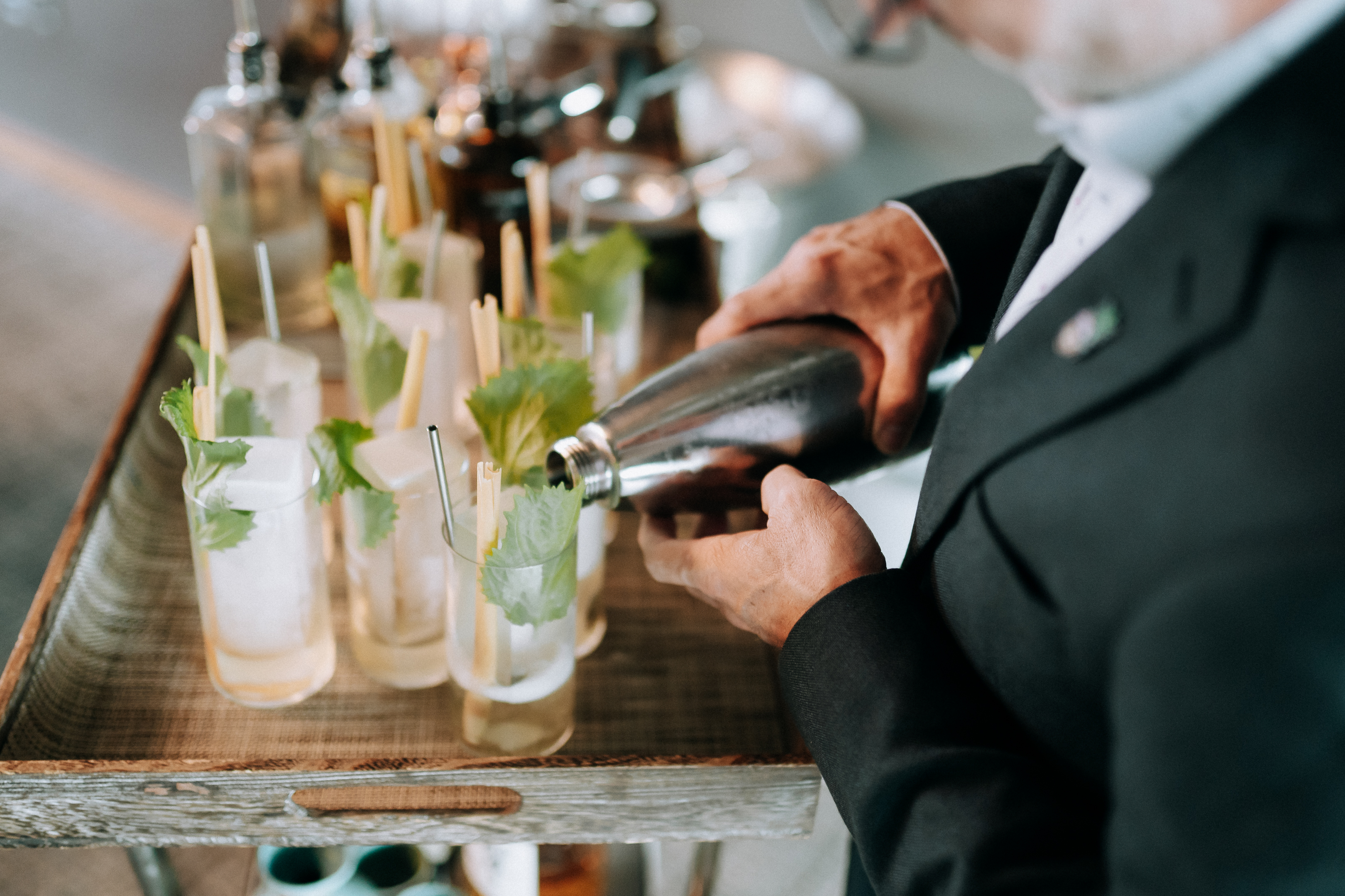 a person pouring a drink into a glass